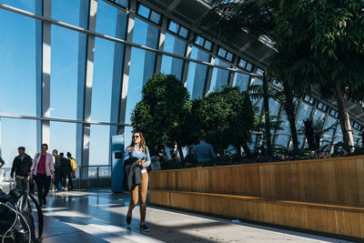 People by glass window in city