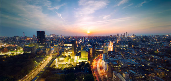 High angle view of illuminated cityscape against sky during sunset