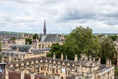 Buildings in city against cloudy sky