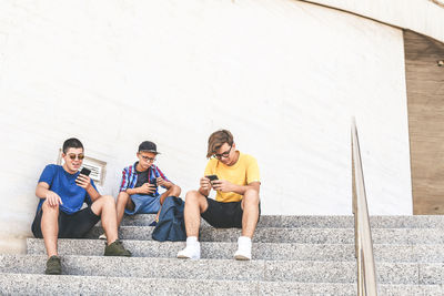 Teenagers using smartphone together. smiling teens browsing social media online. boys watching video