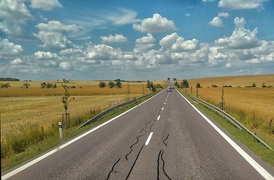 Road by landscape against sky