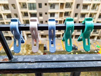 Close-up of clothespins on railing