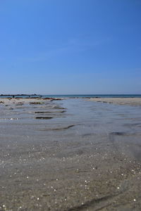 Scenic view of beach against clear blue sky