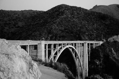 Arch bridge against mountains
