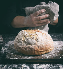 Close-up of person with bread at counter