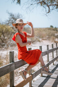 Thoughtful young woman sitting on railing