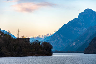 Scenic view of lake by mountains against sky during sunset