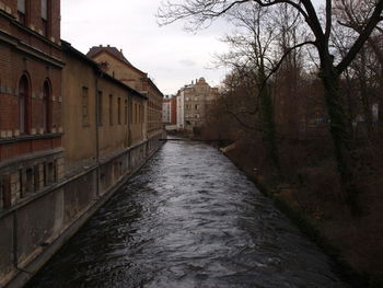 Canal amidst buildings against sky