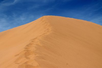 Sand dune in sahara desert against blue sky