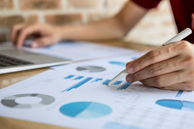 Cropped image of businesswoman working on graph in office