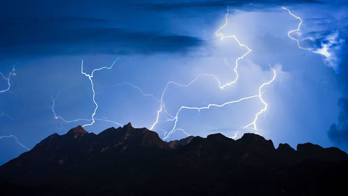 Low angle view of lightning over mountain