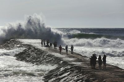 People at beach against sky