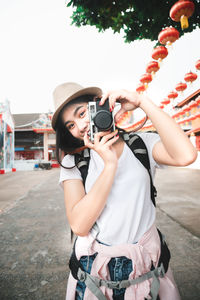 Young woman wearing hat while standing outdoors