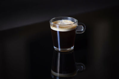 Close-up of a single cup of cappuccino on glossy table