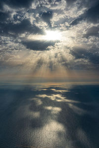 Sunlight streaming through clouds over sea