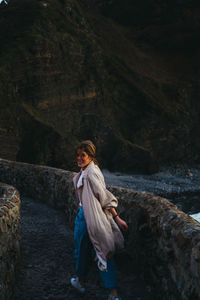 Side view of woman standing on rock