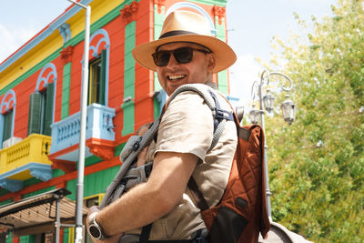  happy man, father carrying little newborn baby in backpack,family traveling, going sightseeing 