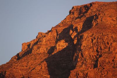 Low angle view of rocky mountains against clear sky