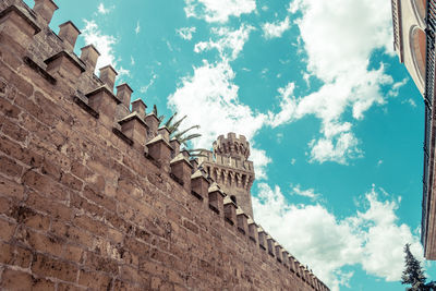 Low angle view of old ruin building against cloudy sky