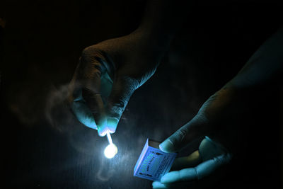 Close-up of hand holding illuminated lighting equipment