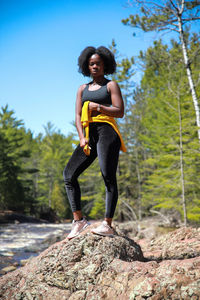 Side view of woman exercising on rock