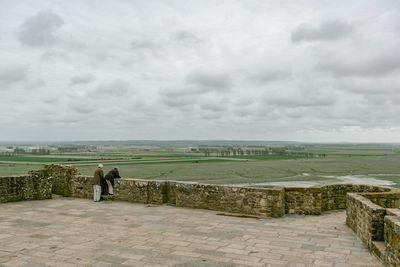 Rear view of man standing on land against sky