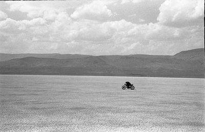 Man riding motorcycle on mountain against sky