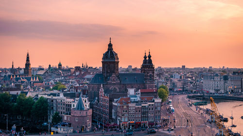 Aerial view of buildings in city during sunset