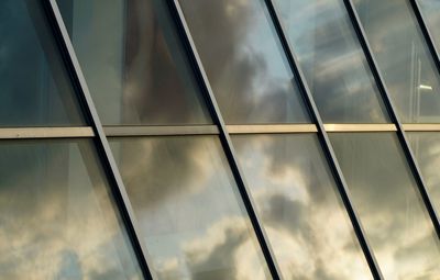 Low angle view of glass building against sky