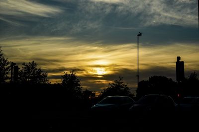 Cars on road against sky during sunset