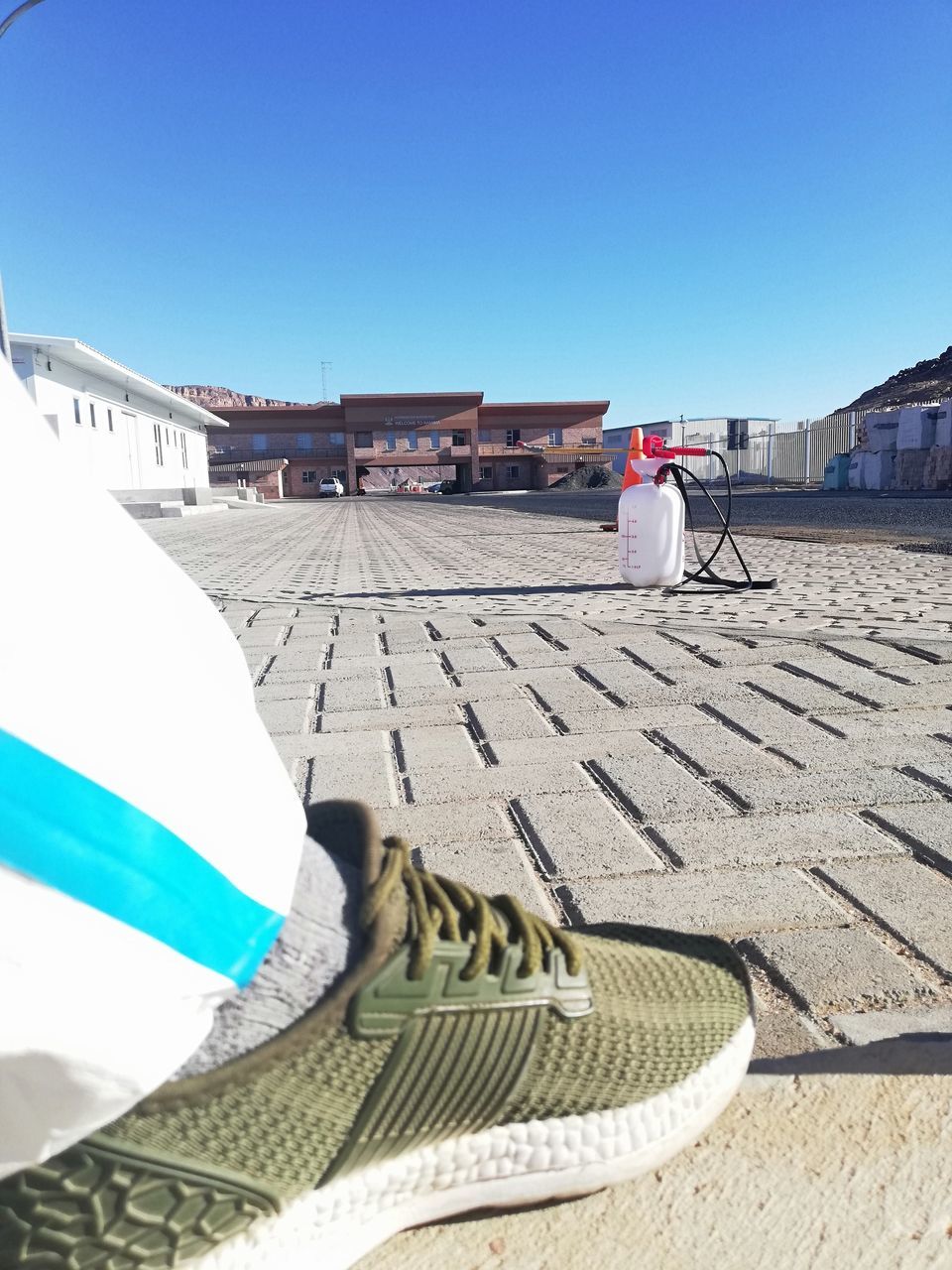 REAR VIEW OF MAN ON BUILDING AGAINST CLEAR BLUE SKY AND