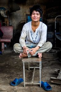 Portrait of a smiling young man sitting on floor