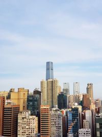 Modern buildings in city against cloudy sky