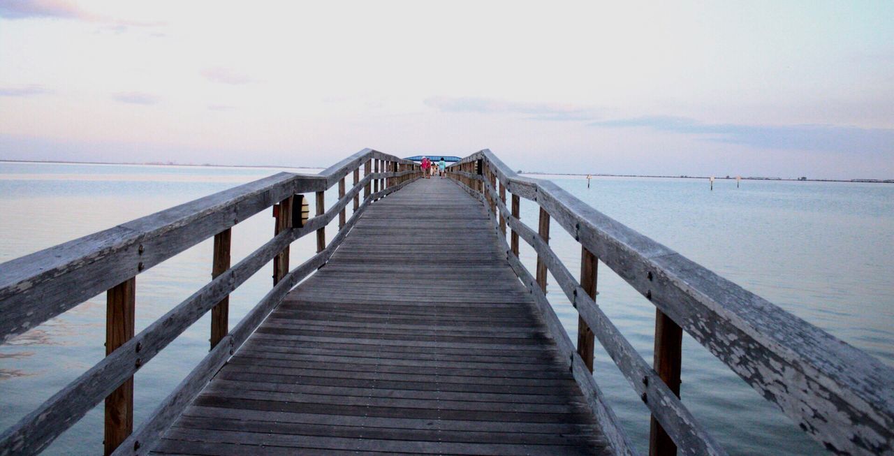 WOODEN PIER ON BEACH AGAINST SKY