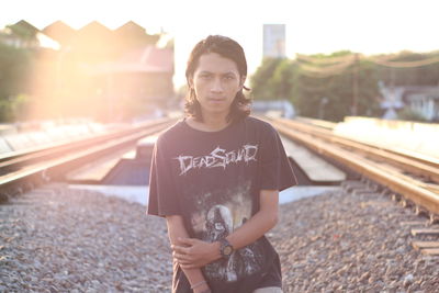 Portrait of man standing on railroad track