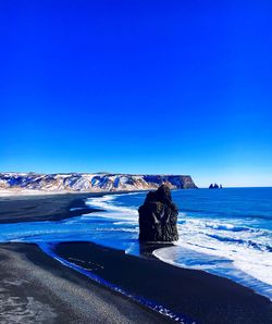 Scenic view of sea against clear blue sky during winter