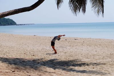 Full length of woman on beach against sky