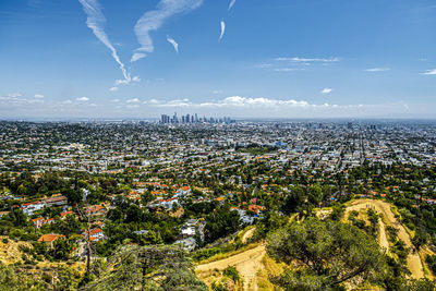 Aerial view of city by sea against sky