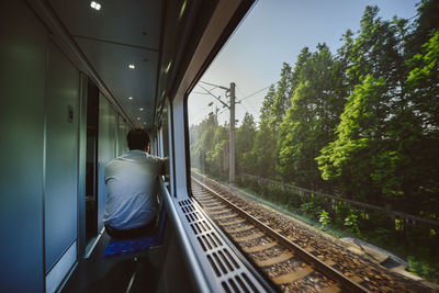 Rear view of man traveling in train