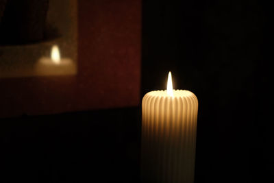 Close-up of lit candle in the dark