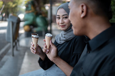 Side view of man holding ice cream