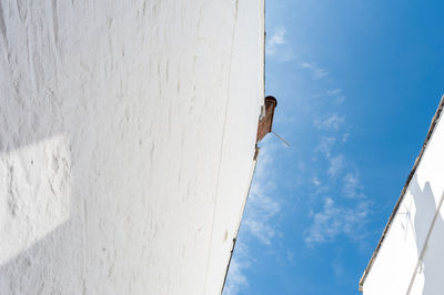 Low angle view of white wall against blue sky