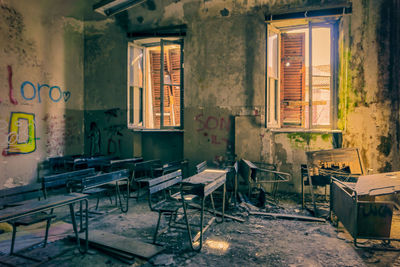 Empty chairs and table in abandoned building