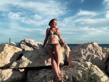 Full length of young woman on rock at beach