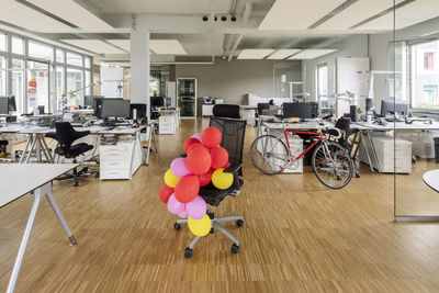 Bunch of balloons on chair in open plan office