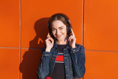 Portrait an attractive young woman smiling with wireless headphones against