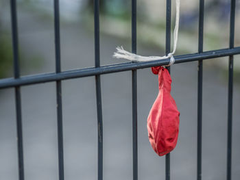 Close-up of red tied hanging on metal railing