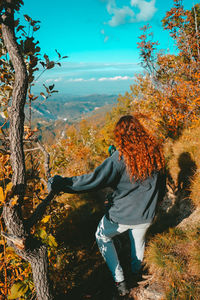 Rear view of woman standing against landscape and sky