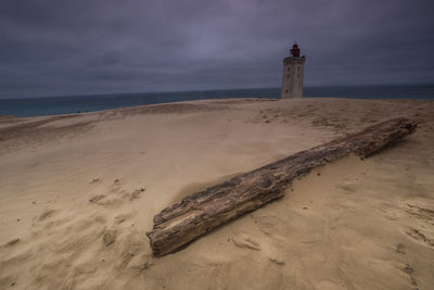 Lighthouse rubjerg knude at sunset on a stormy evening with dramatic sky