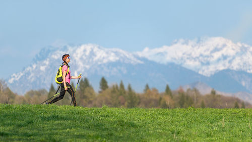 Woman on field by mountains against sky